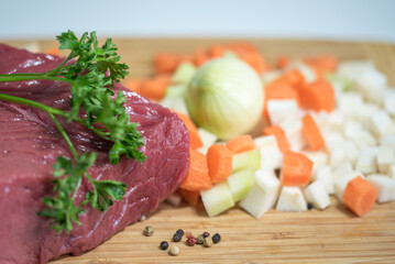 Raw beef meat on a cutting board with fresh vegetable - 764619873