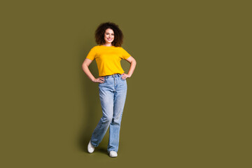 Full body size photo of young charming beautiful wavy hair woman in yellow t shirt and jeans posing isolated on khaki color background © deagreez