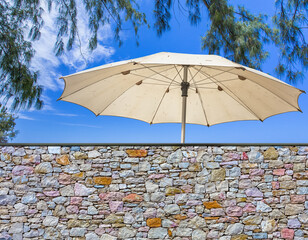 Parasol derrière mur de pierres 