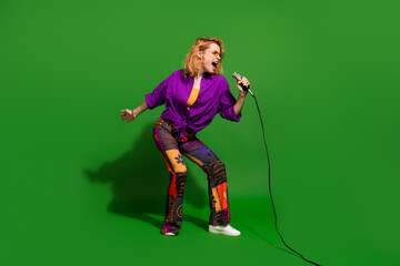Photo portrait of pretty young girl singing concert enjoy karaoke wear trendy purple outfit isolated on green color background