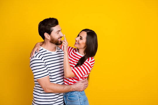 Photo of adorable girl hold finger on guy nose dressed striped t-shirt cuddle together isolated on vibrant yellow color background