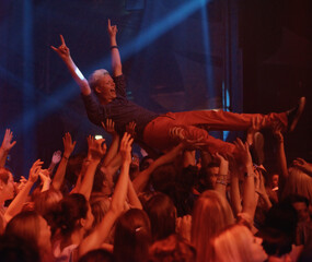 Person, excited and crowd surf at concert, live show and performance for heavy metal band at night....