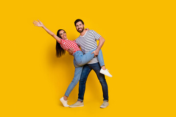 Full size photo of positive nice couple dressed striped t-shirt dancing together girl waving hand isolated on yellow color background
