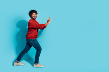 Full size profile photo of cheerful nice person hands push empty space ad wall isolated on blue...
