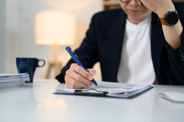 Stressed senior businessman holding his head working at office desk