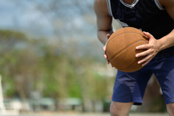 Cropped shot of sportsman dribbling the ball on an outdoor court. People, sport and active lifestyle concept