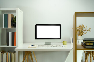 Front view of blank computer screen on white table in modern home office