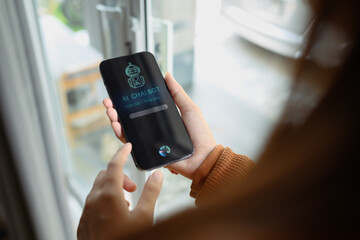 Over shoulder view of woman using AI Chat bot in mobile application and giving voice commands