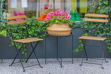Fototapeta na wymiar Two Chairs and Flowers Pot Decor in Front of Shop Window