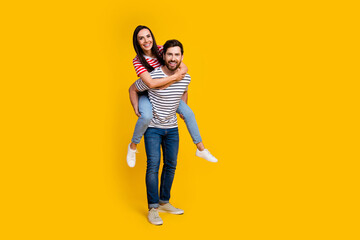 Full size photo of good mood funny couple dressed striped t-shirt guy hold girlfriend on his back...