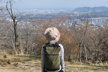 山頂から景色を眺めるハイカーの女性の後ろ姿