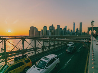 beautiful sunset over manhattan with manhattan and brooklyn bridge.  Brooklyn Bridge illuminate at...