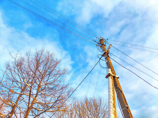 Old pole with wires against the sky. Electric transmission line. Eco-friendly energy