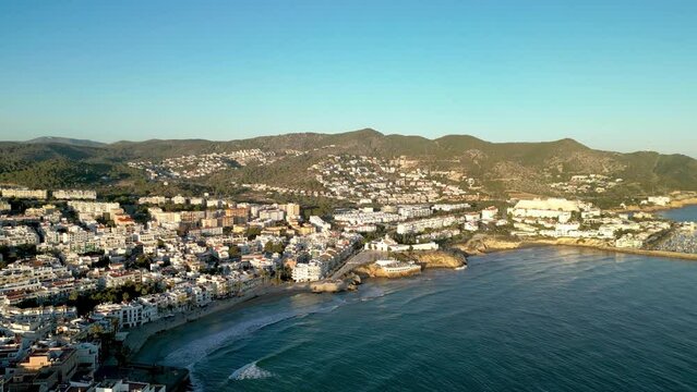 Sitges, Catalonia - Spain Aerial view. Drone going backwards above the bay. View of part of the city and port area. Costal city, famous travel destination. Sunset point