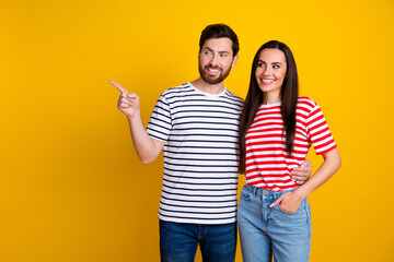 Obraz premium Photo portrait of attractive young couple hugging point look empty space wear trendy striped clothes isolated on yellow color background