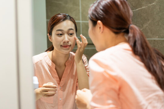 Photo of young Asian woman in bathroom