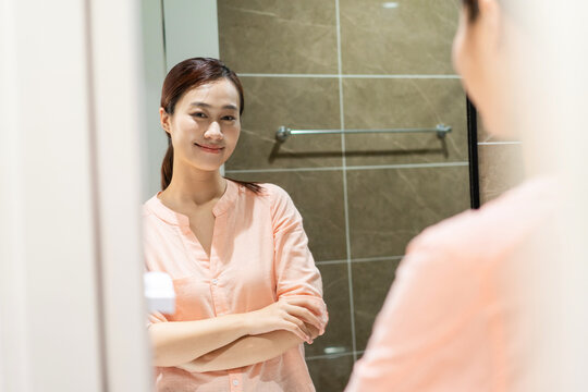 Photo of young Asian woman in bathroom