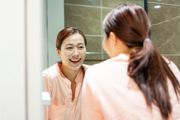 Obraz na płótnie Canvas Photo of young Asian woman in bathroom