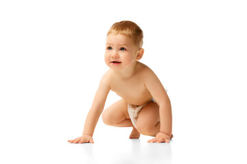 Happy little baby boy in diaper child sitting, smiling, playing isolated over white studio...