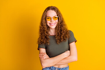 Photo of adorable gorgeous girl dressed nice outfit standing crossed arms isolated on yellow color background © deagreez