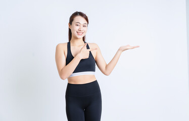 Young Asian woman wearing sportswear on white background