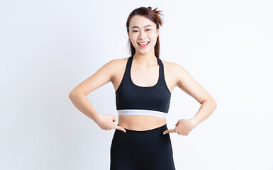 Fototapeta na wymiar Young Asian woman wearing sportswear on white background