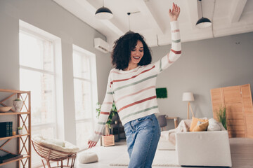 Photo of carefree dreamy lady dressed striped pullover dancing smiling indoors apartment room