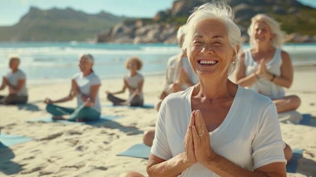 A group of active seniors laughing and enjoying a yoga class on a sunny beach