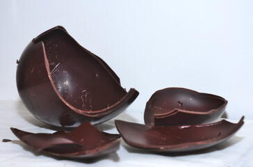uova di cioccolata rotta in tanti pezzi per pasqua 2024. pranzo pasquale. cioccolato fondente. cioccolato su sfondo bianco 