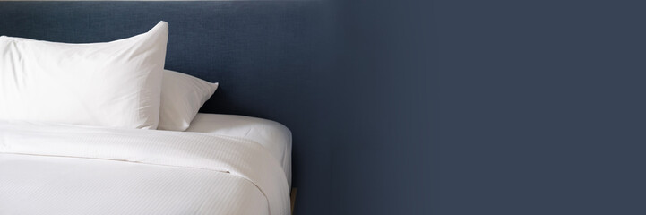 Obraz premium Clean, made hotel bed with white linens. Pillow, blanket on a bed with a soft headboard. Banner with free space for text