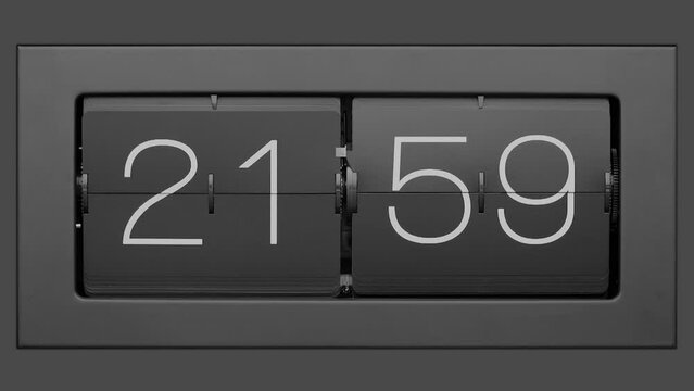 Flip clock quickly flips. .Retro flip clock changing from 21:59 to 22:00. Slow motion. Close up.