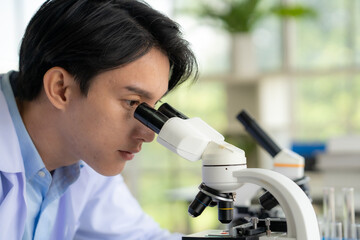 A medical technician is using a microscope to examine blood results on a patient.