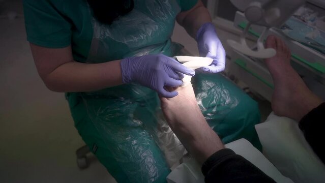 The podiatrist bandages the thumb with a bandage, profession of podiatrist 