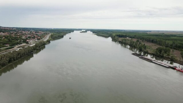 Aerial view of large woodland on riverbank of Danube and town on other side