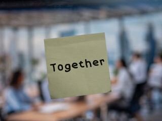 Post note on glass with 'Together'.