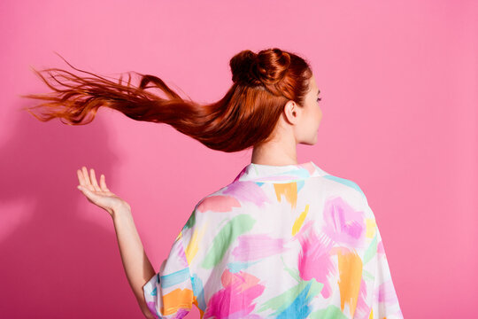 Rear view photo of gorgeous cute girl dressed colorful blouse throw up red tails think to cut hairdo isolated on pink color background