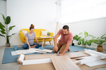 Pregnant couple building furniture in new home. High quality FullHD footage