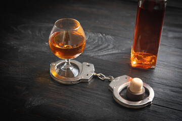 Handcuffs with a glass of cognac.
