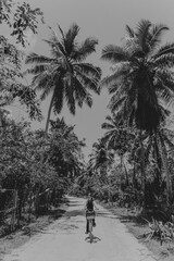 Fototapeta na wymiar Girl riding a bicycle with palm trees nature decor black and white