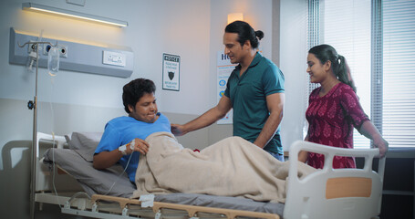 Portrait of Young Indian Couple Visiting Their Friend After his Surgery in a Hospital. Recovering...