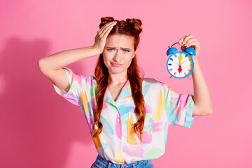 Portrait of disappointed sad woman wear print shirt hold alarm arm on head forget about deadline isolated on pink color background