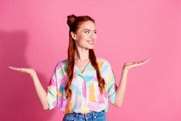 Portrait of positive woman with foxy hairstyle wear print shirt look at best option on arm empty...