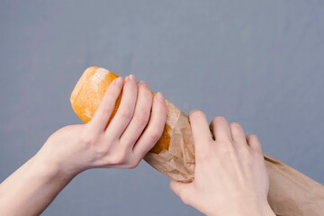 Hold loaf of bread in your hand and try to break it. Bread in a - obrazy, fototapety, plakaty
