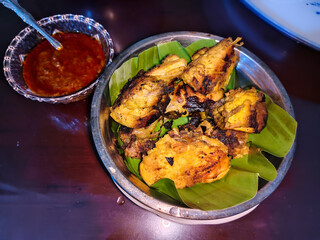 several pieces of grilled chicken in a stainless steel bowl