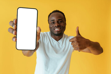 White display of smartphone for copy space. Black man is in the studio against yellow background