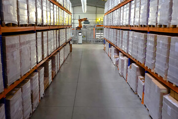 Large warehouse with goods on shelves of racks.