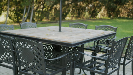 Empty tables with chairs pulled up - summer terrace of the cafe without visitors