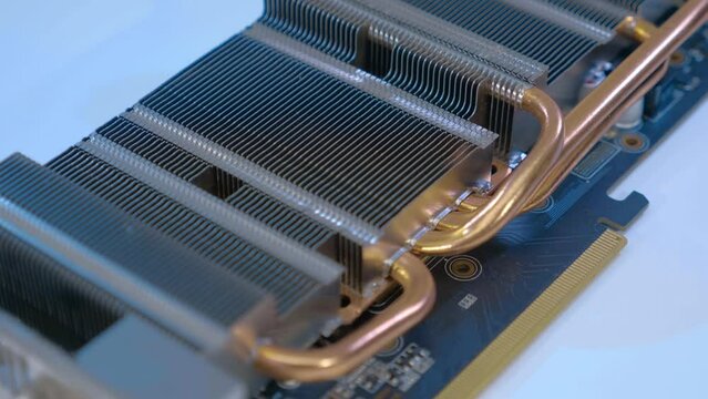 Powerful radiator with copper tubes for circulating coolant to cool the computer video card. Closeup. Macro. Shallow depth of field. Shot in motion