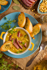 Traditional Polish pea soup. Prepared with smoked meat. Served in a yellow bowl with croutons. Home made.