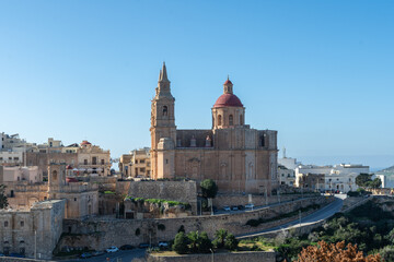 Fototapeta premium Mellieha, Malta - December 25th 2022: The 19th century Parish Church of the Nativity of the Virgin Mary alongside the 16th century church the Sanctuary of Our Lady of Mellieħa.